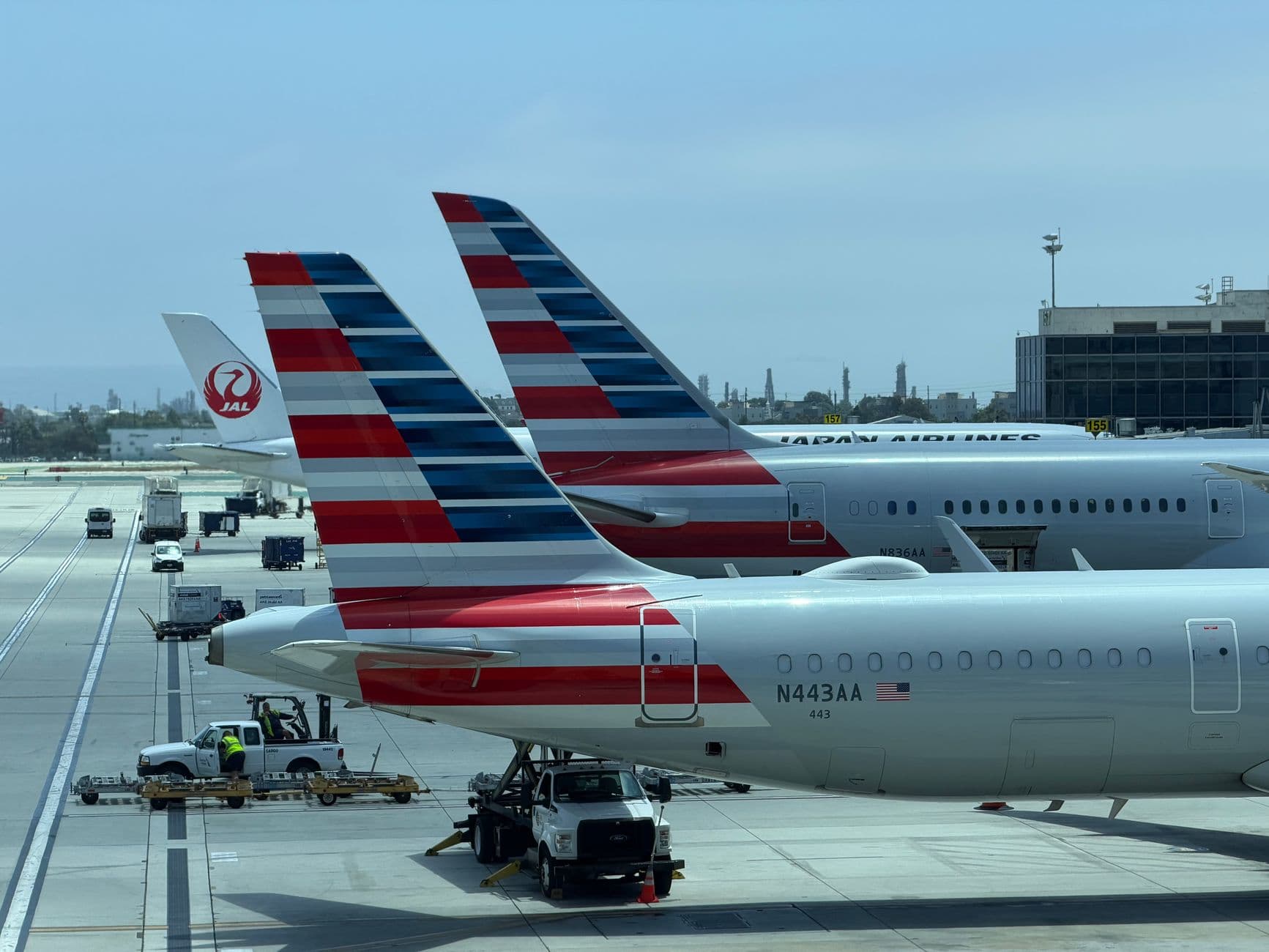 American Airlines aircraft with silver fuselage and flag tail at terminal