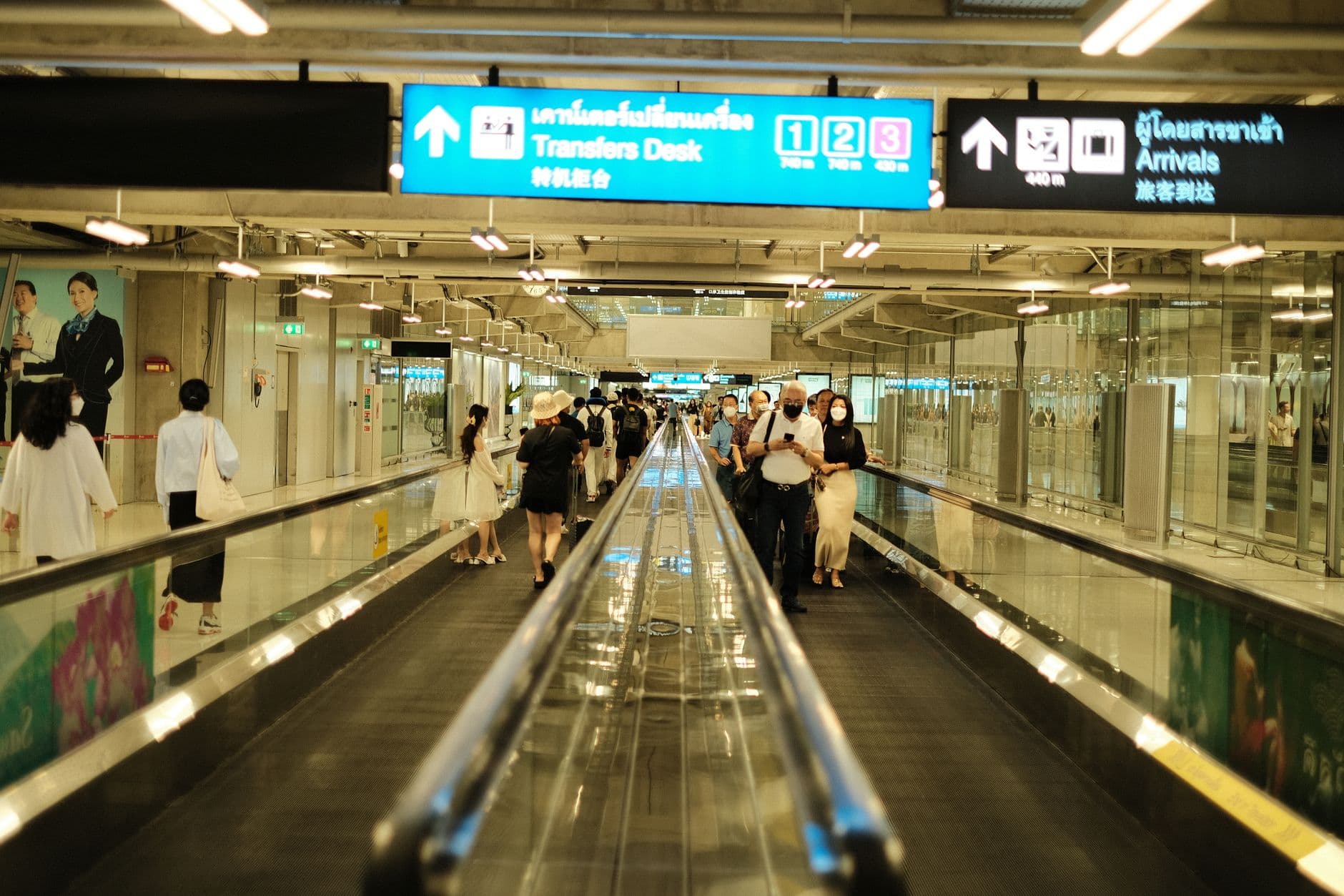 Airport moving walkway in a modern corridor with travelers