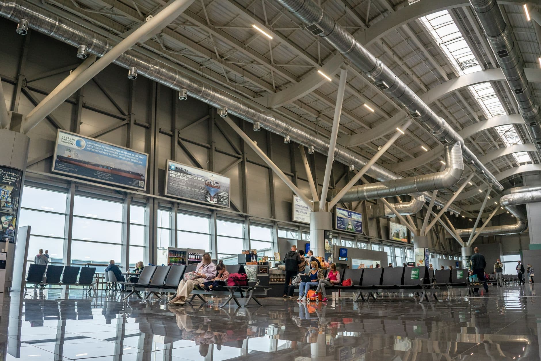 Modern airport terminal with sleek architecture and travelers walking through gates