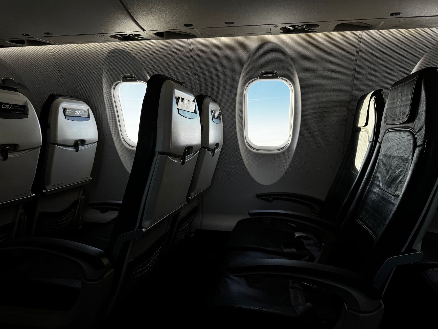 Economy class airplane cabin with rows of passenger seats