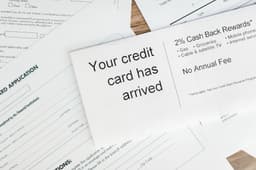 Several travel rewards credit cards arranged on a table representing bank points transfer programs
